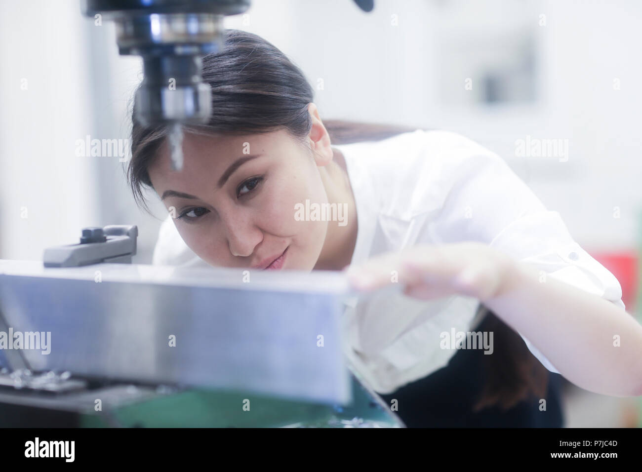 Ingenieurin Vorbereitung ein Loch in einer Metallschiene zu bohren Stockfoto