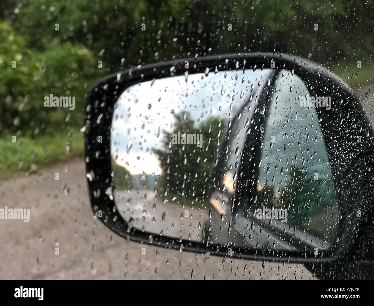 Autos auf der autobahn im regen im seitenspiegel. nahaufnahme