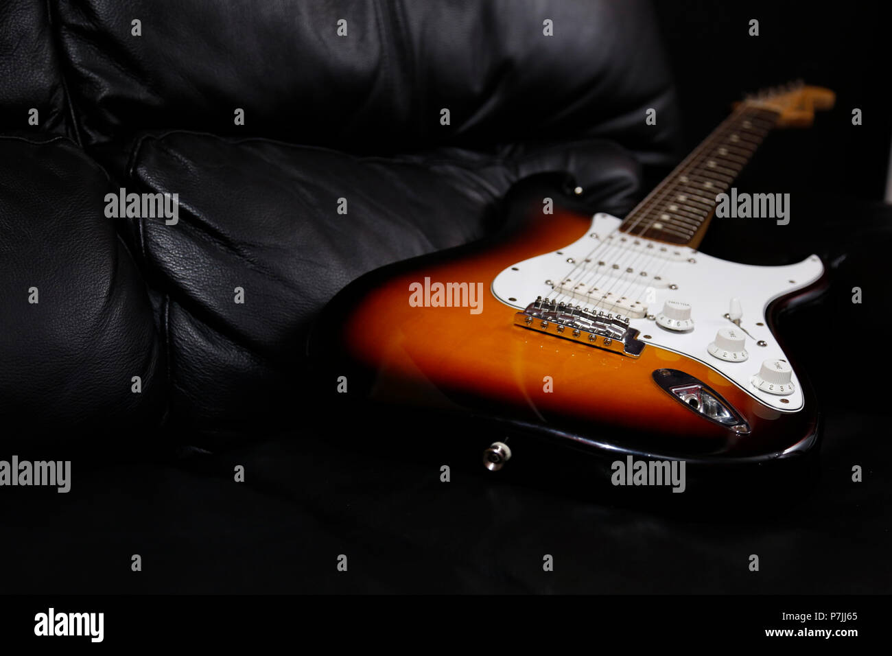 E-Gitarre liegend auf dem Sofa Stockfoto