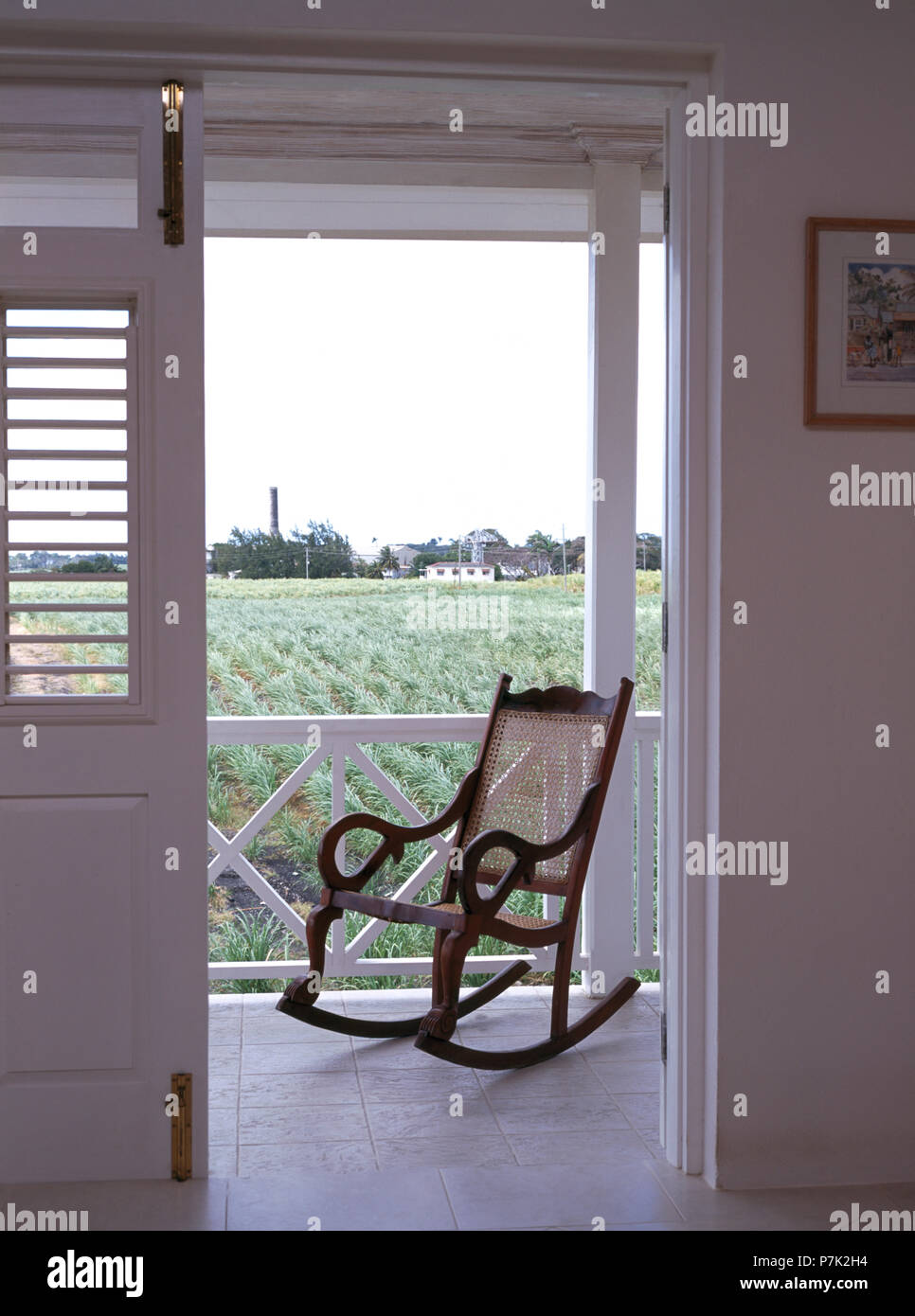 Blick durch die offenen Türen der Schaukelstuhl auf der Veranda eines Caribbean House Stockfoto