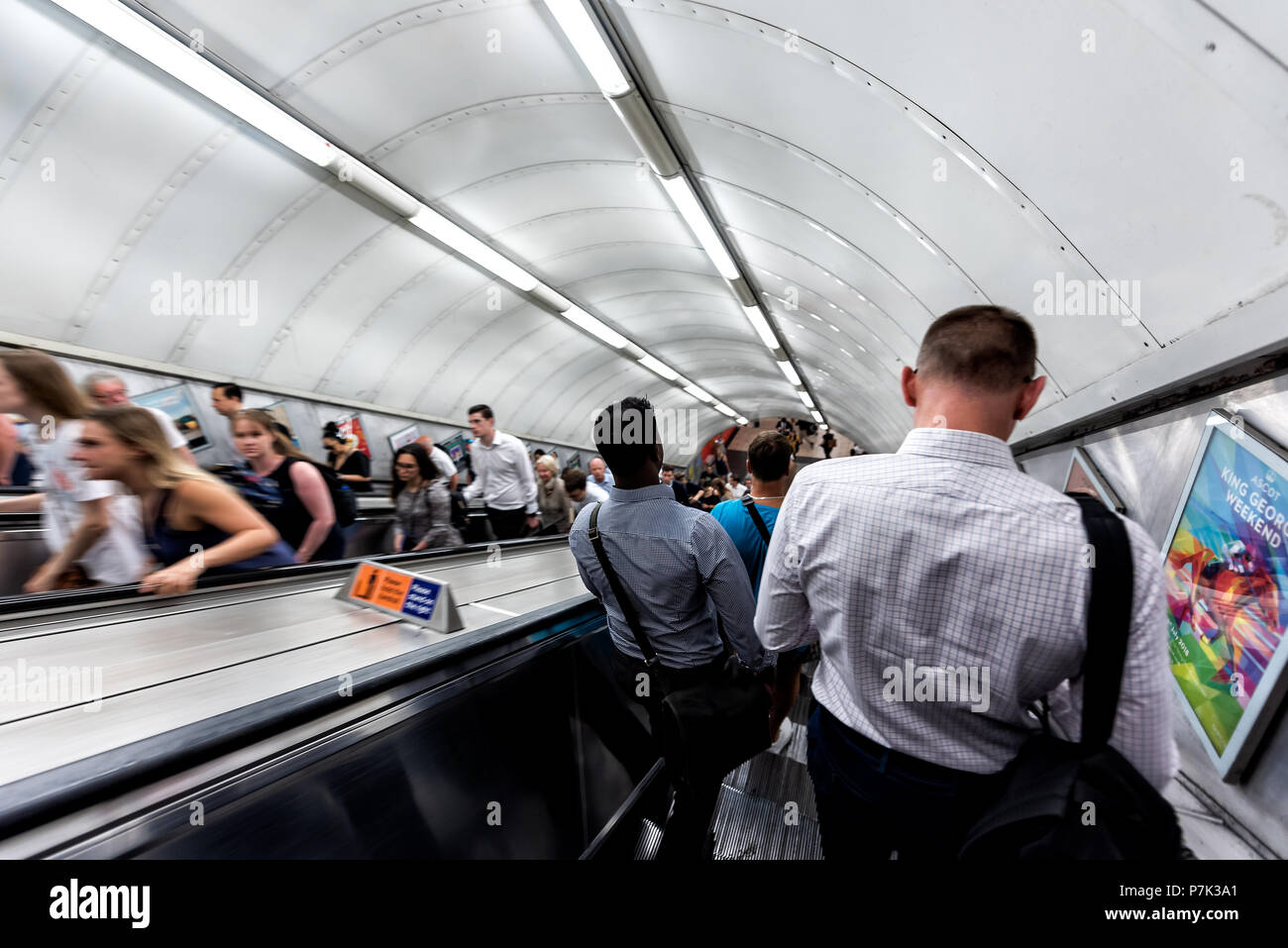 London, UK, 26. Juni 2018: Die Männer reiten Rolltreppe nach unten wandern in U-U-Bahn während der morgendlichen Fahrt zum Arbeitsplatz im Zentrum der Innenstadt von Stadt in Stockfoto
