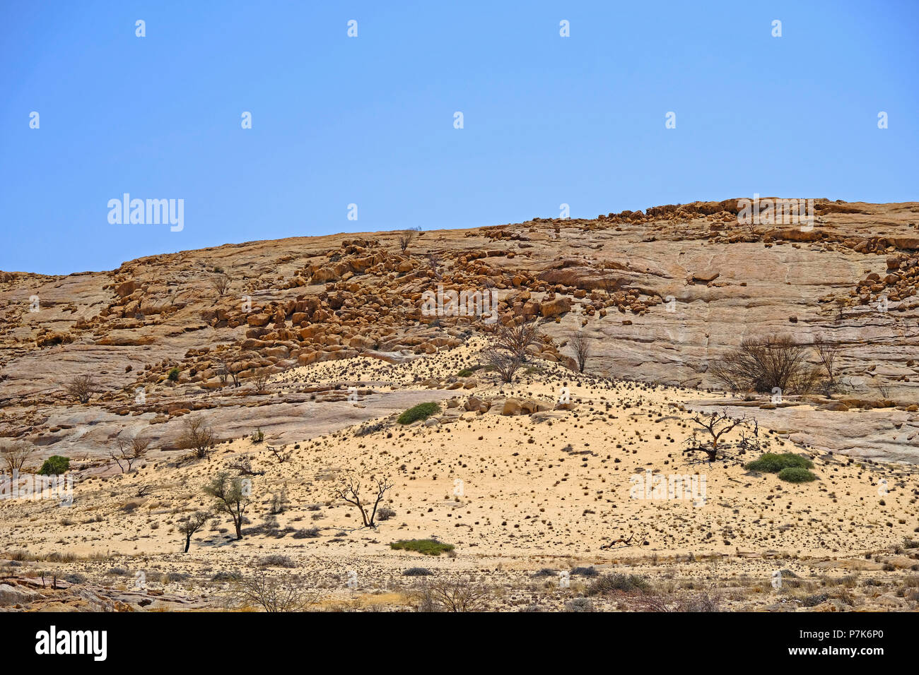 Großer monolith Felsen mit Erodierten Granit Kugeln, Sandverwehungen und spärliche Vegetation in der Brandberg in Namibia Damaraland Stockfoto
