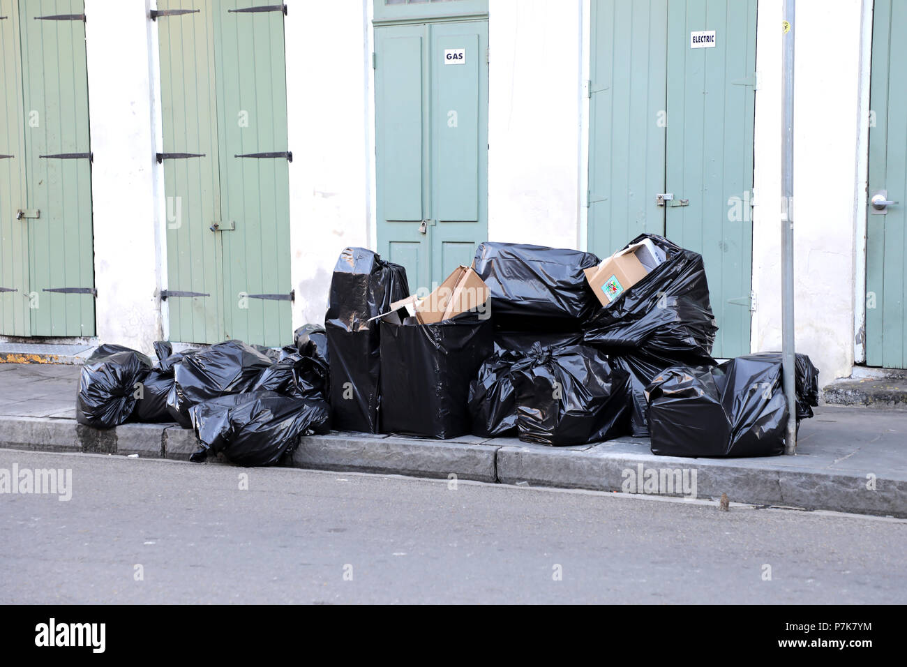 Schwarze Müllsäcke auf Bürgersteig in New Orleans, Louisiana, USA Stockfoto