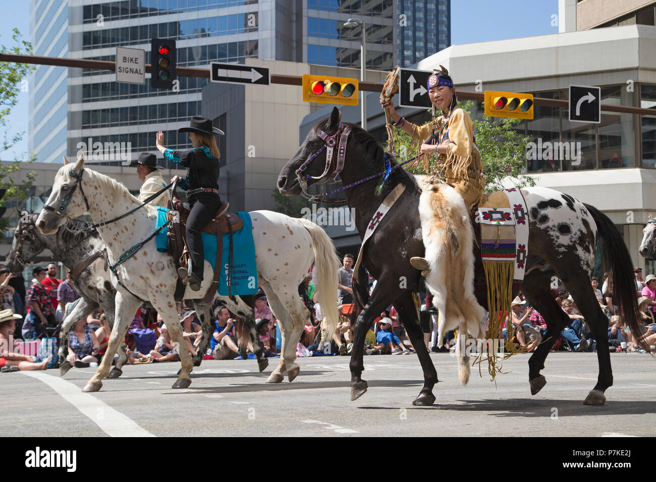 Frauen in traditionellem indigenem und Cowboy-Kleid, die den Calgary Regional Appaloosa Club bei der Calgary Stampede Parade repräsentieren. Die Parade durch die Innenstadt beginnt jedes Jahr mit der Calgary Stampede. Alberta, Kanada. Rosanne Tackaberry/Alamy Live News Stockfoto