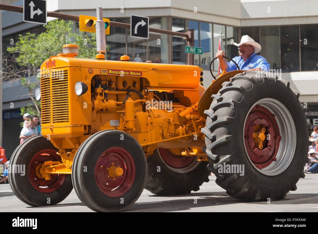 Man fährt Minneapolis Moline G Modell Vintage Traktor in der Calgary Stampede Parade. Die Parade durch die Innenstadt startet jedes Jahr die Calgary Stampede. Rosanne Tackaberry/Alamy Live News Stockfoto
