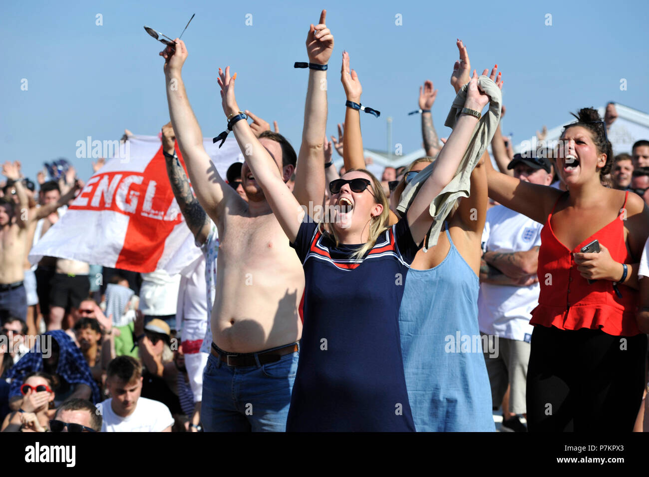 Brighton UK 7. Juli 2018 - England Fans feiern schlagen Schweden 2-0 wie Sie einen riesigen Bildschirm ansehen auf Brighton Beach in das WM-Viertelfinale Fußballspiel zwischen England und Schweden heute: Simon Dack/Alamy Leben Nachrichten: Simon Dack/Alamy leben Nachrichten Stockfoto