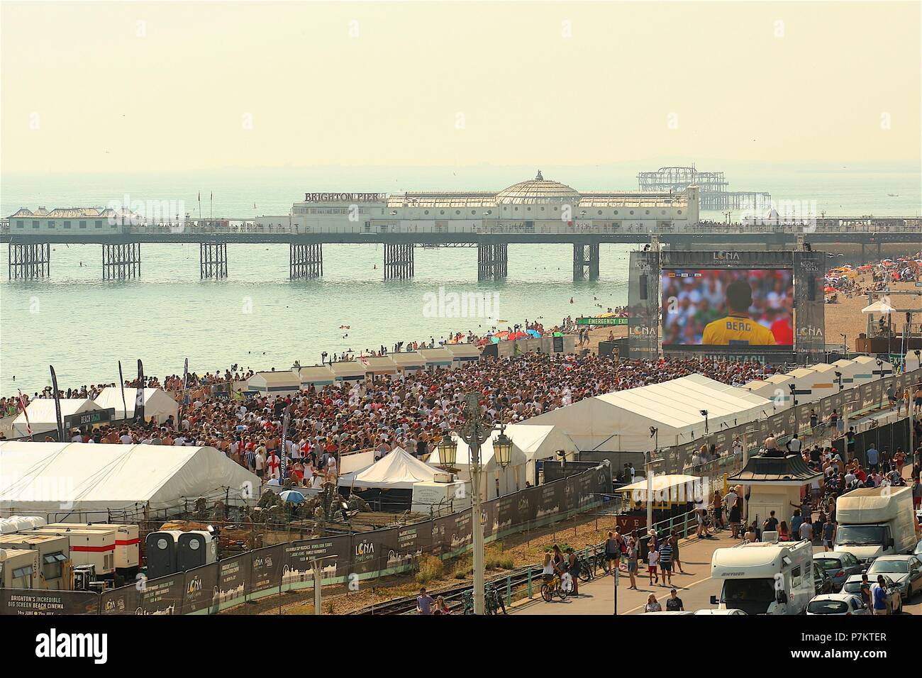 Brighton, UK. 7. Juli 2018. Fußball-Fans auf Brighton Beach beobachten die grossen Schirm am Strand durch die Barrieren der Credit: Rupert Rivett/Alamy leben Nachrichten Stockfoto