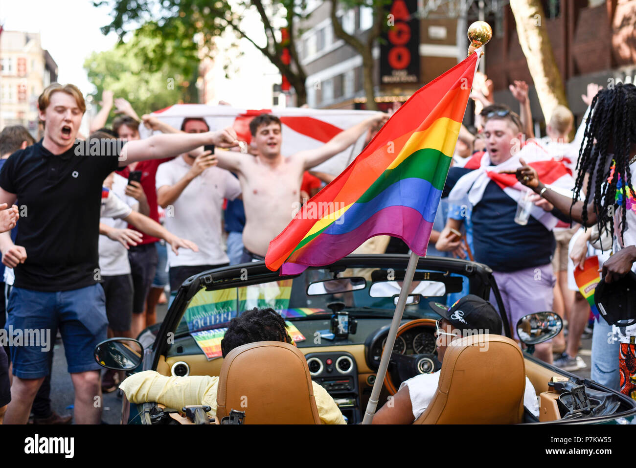 London, Großbritannien. Vom 7. Juli 2018. England Fans in der Hauptstadt Feiern des England National Team 2-0 Sieg gegen Schweden im Viertelfinale der WM in Russland. Jubelnde Fans in Charing Cross Road Stop Datenverkehr, der Ruf "Fußball nach Hause kommen". Die jährlichen Stolz London Veranstaltung ist auch im Bereich mit Happy rainbow plattiert Stolz die Teilnehmer begeistert, da gut zu feiern. England ist der Gewinner des Home Team Russland oder Kroatien im Halbfinale. Credit: Stephen Chung/Alamy leben Nachrichten Stockfoto