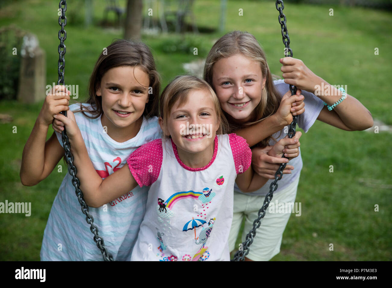 Drei Mädchen lachend an eine Schaukel im Garten Stockfoto