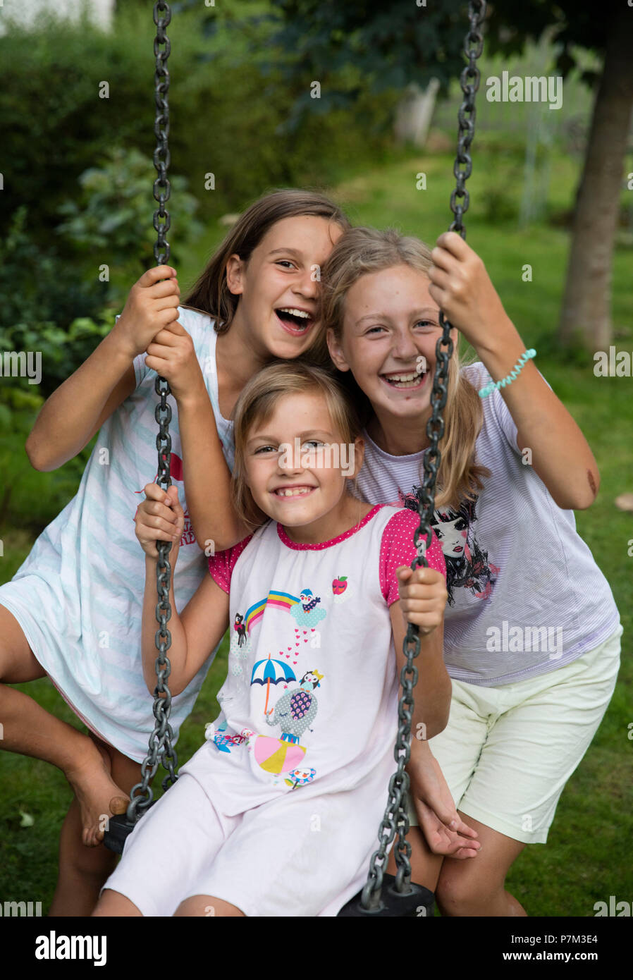 Drei Mädchen lachend an eine Schaukel im Garten Stockfoto