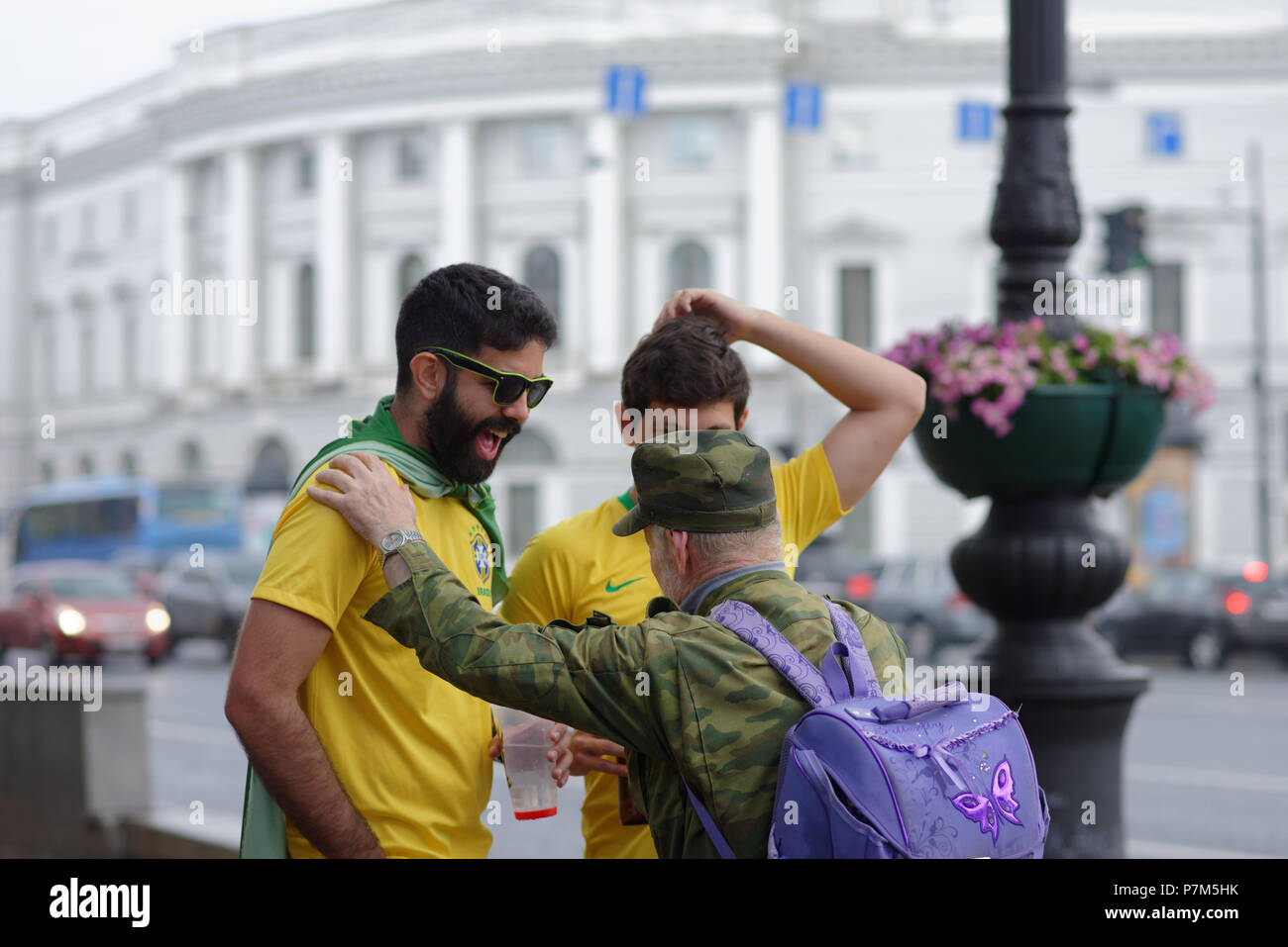 St. Petersburg, Russland - Juli 6, 2018: Lokale alter Mann im Gespräch mit dem brasilianischen Fußball-Fans am Newski-prospekt vor dem Viertelfinale Spiel der FIFA WM Stockfoto