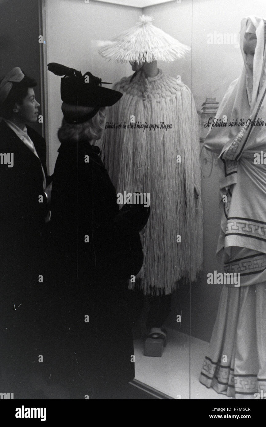 Besucher einer Messe vor einer Vitrine mit chinesischen und griechischen Kostümen, anlässlich der Wiener Modewoche im Haus der Mode "Palais Lobkowitz", Deutschland 1940. Stockfoto