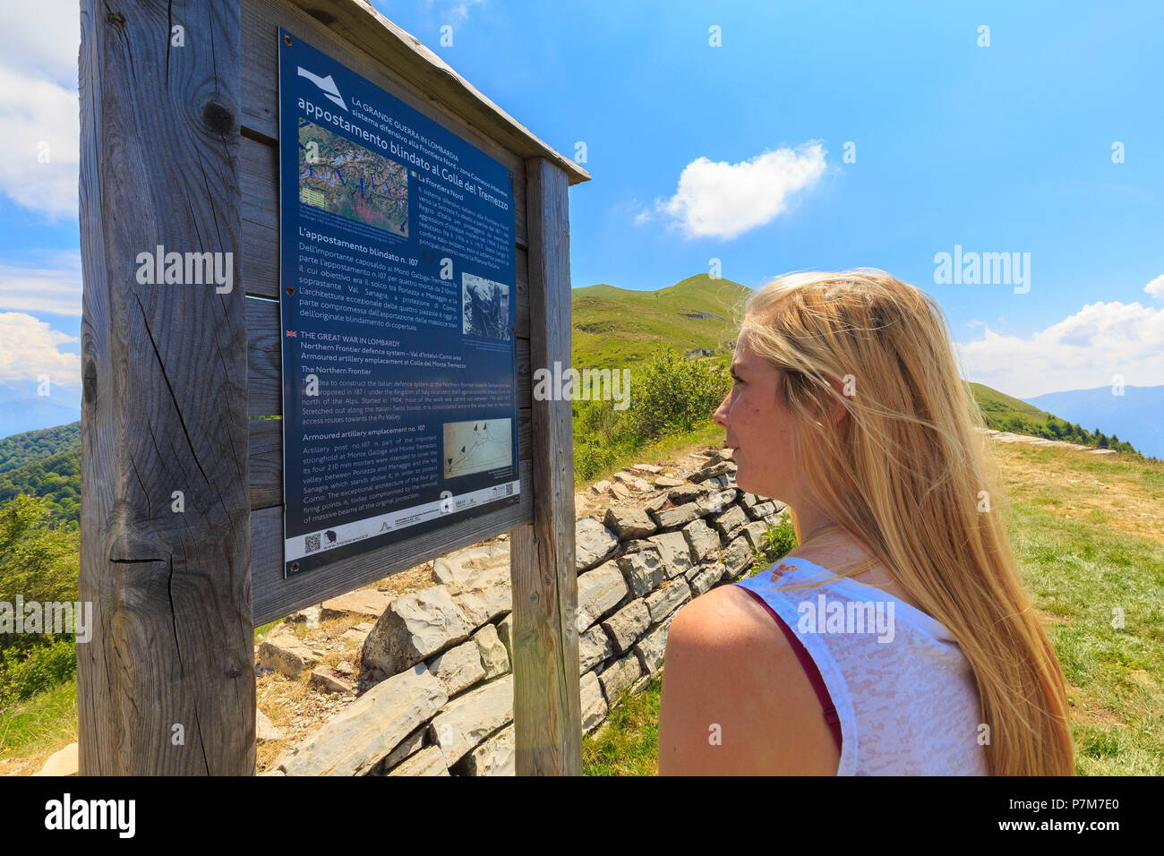 Ein Mädchen liest eine informative Zeichen an der Alpe Colonno, Pigra, Val d'Intelvi, Comer See, Lombardei, Italien, Europa. Stockfoto