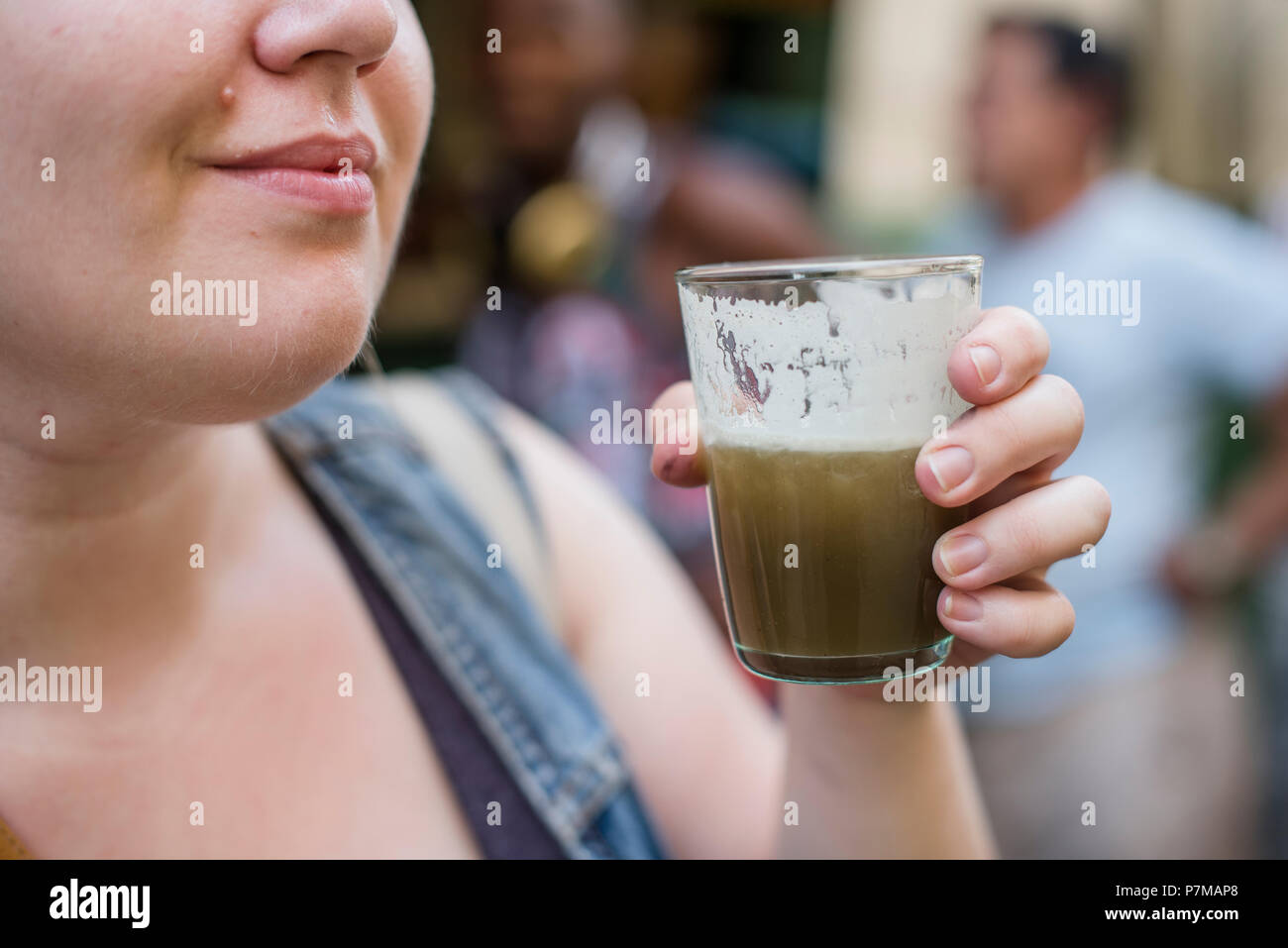 Ein Tourist versucht guarapo - ein gepresstes Zuckerrohr drink - Zum ersten Mal beim Wandern rund um Havanna. Stockfoto
