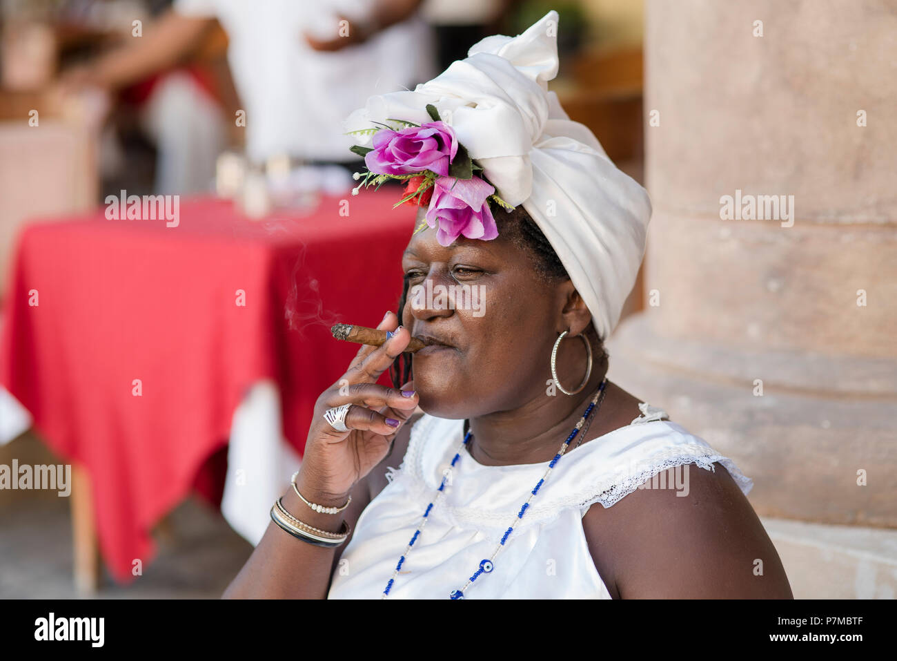 Theresa die Wahrsagerin eine kubanische Zigarre rauchen und genießen das schöne Wetter auf der Plaza de la Catedral, Havanna, Kuba. Stockfoto