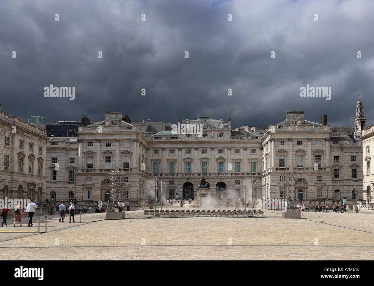 Dramatisches Bild der Courtauld Institute in London, England, teilweise im hellen Sonnenlicht als bedrohliche dunkelgraue Wolke Ansätze über es Stockfoto