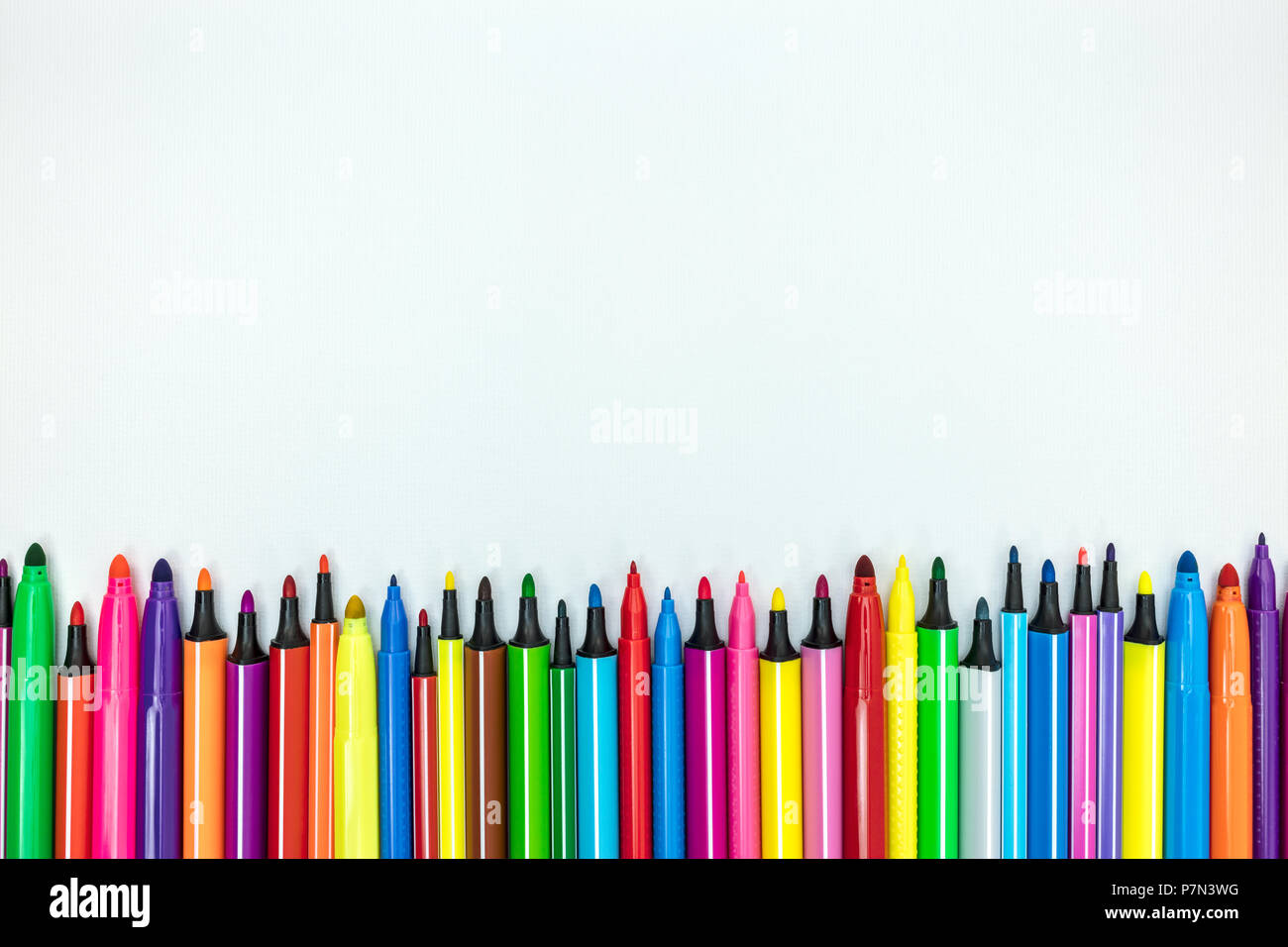 Volksschule liefern. Satz von verschiedenen bunten Markierungen auf weißem Schreibtisch Hintergrund, flache Ansicht Stockfoto
