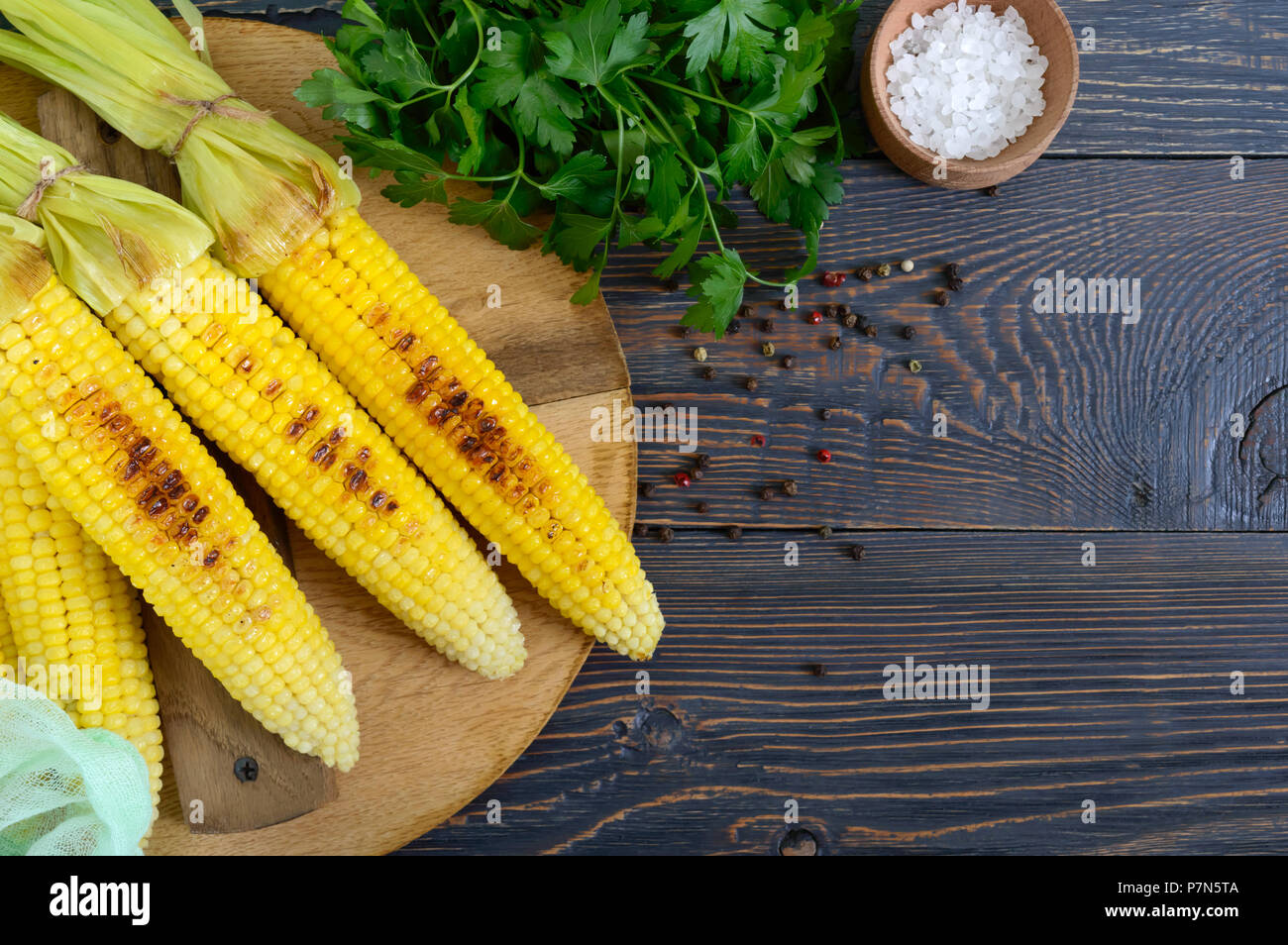 Frische leckere gegrillter Zuckermais mit Butter, Salz und Koriander auf einem Holztisch. Sommer oder Abendessen. Ideen für Grill Parteien. Veg Stockfoto