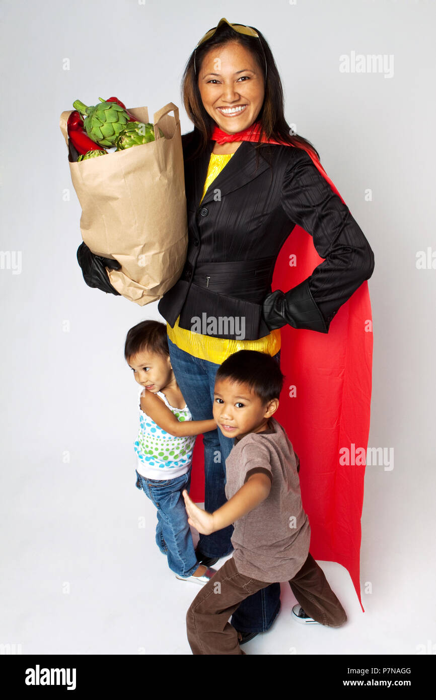 Super Hero mom Lebensmittel Holding mit ihren Kindern. Stockfoto