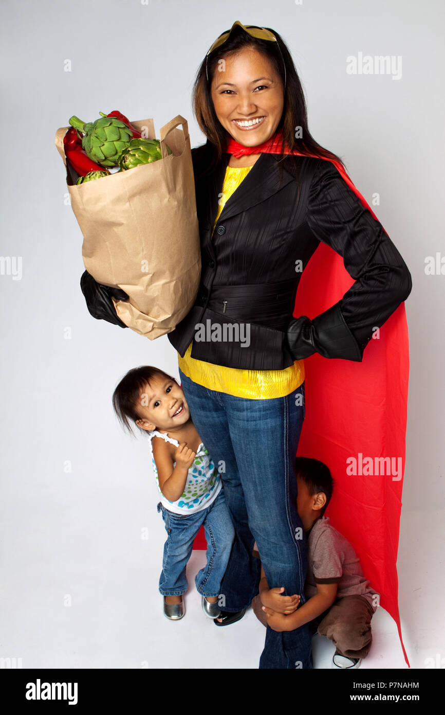 Super Hero mom Lebensmittel Holding mit ihren Kindern. Stockfoto