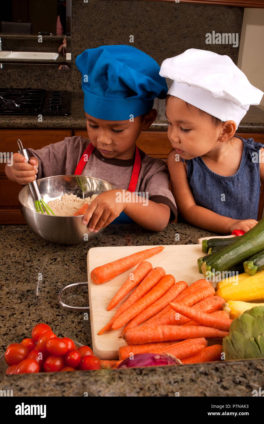 Bruder und Schwester essen und in der Küche. Stockfoto