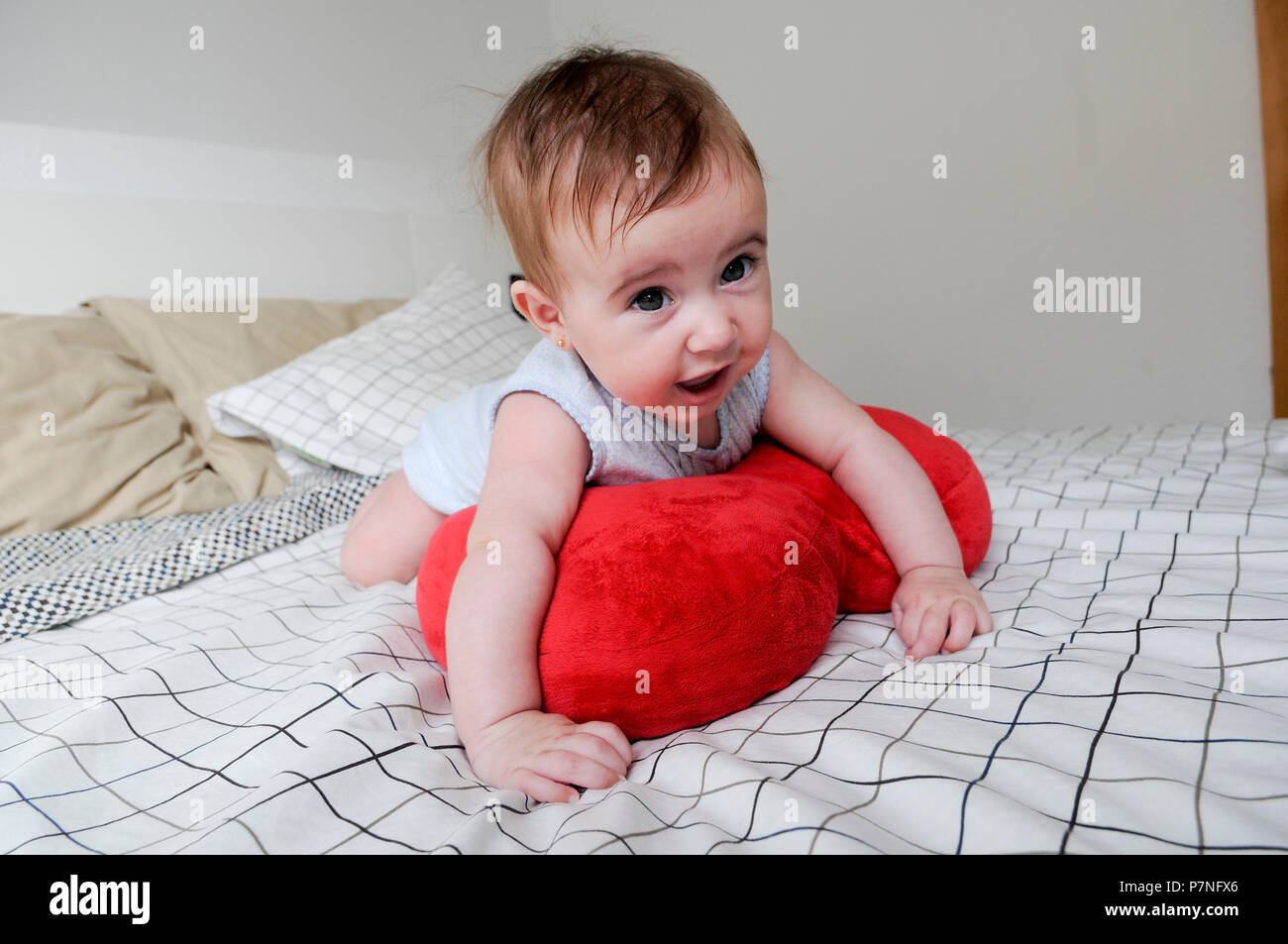 Happy Baby Mädchen, fünf Monate alt, auf dem Bett Stockfoto