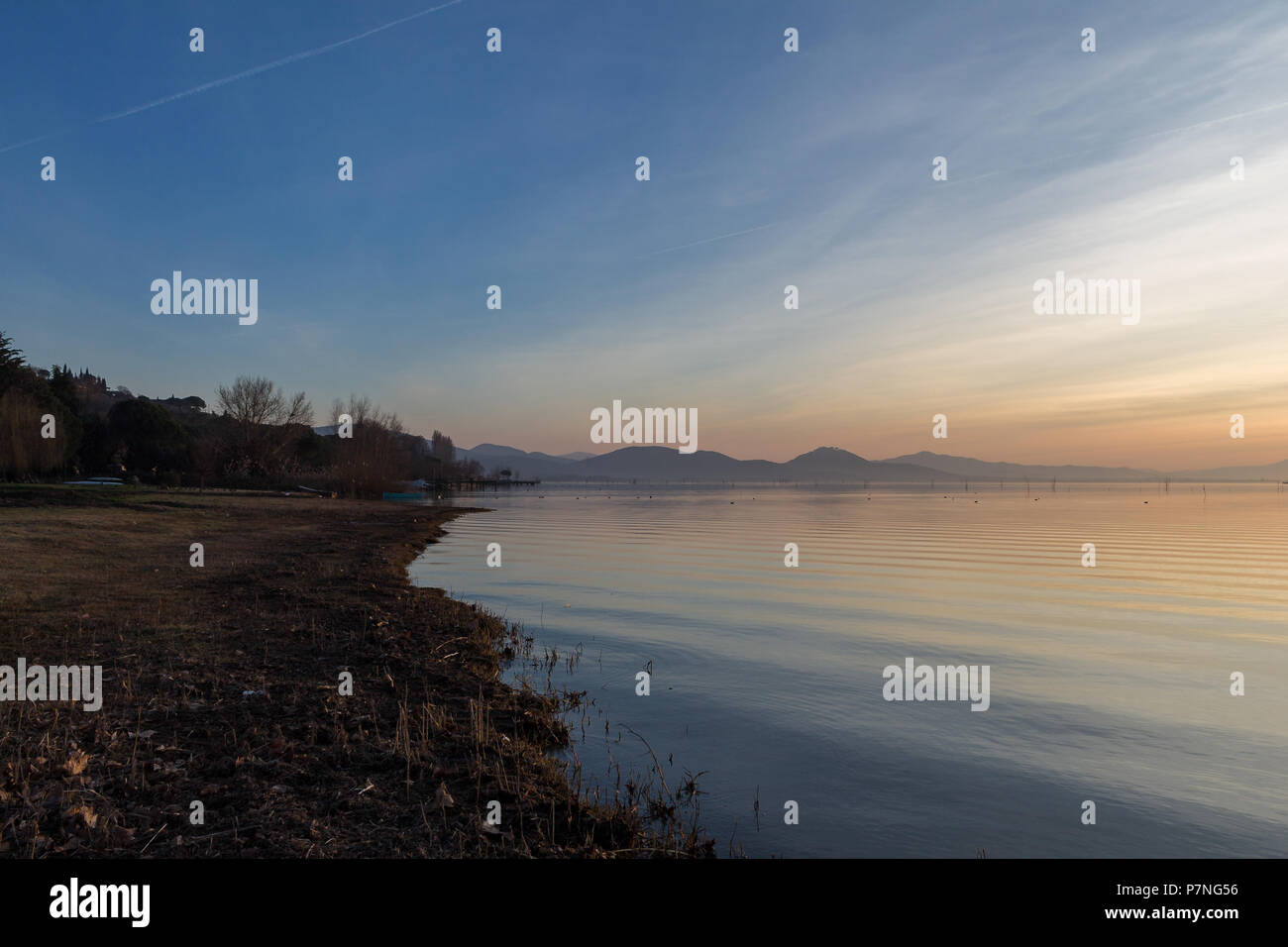 Ein Shooting für einen Sonnenuntergang über einem See, mit schönen, warmen Farben und viele diagonalen Linien durch Wolken und Wasser Wellen erstellt Stockfoto