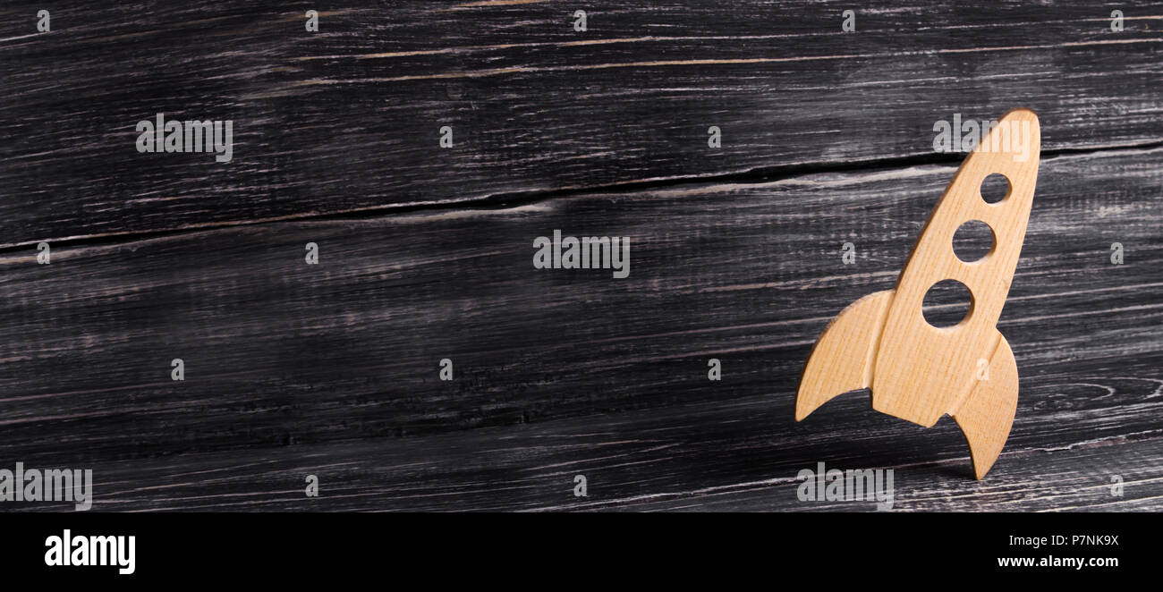 Holz- platz Rakete im Retro Stil liegt auf einem dunklen Hintergrund. Der Raumfahrtindustrie, die Entwicklung der Technik und der Eroberung des Weltraums. Creati Stockfoto