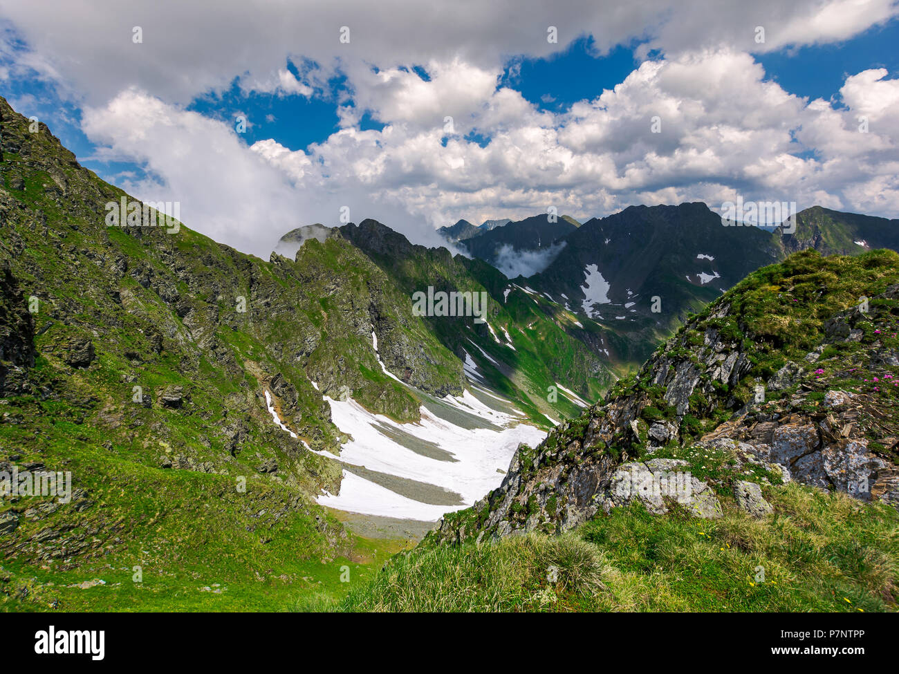 Felsen im Tal der Fagaras Berge. schönen Sommer Landschaft an einem bewölkten Tag. Flecken Schnee auf grasigen Hang. schöne Landschaft von Rumänien Stockfoto