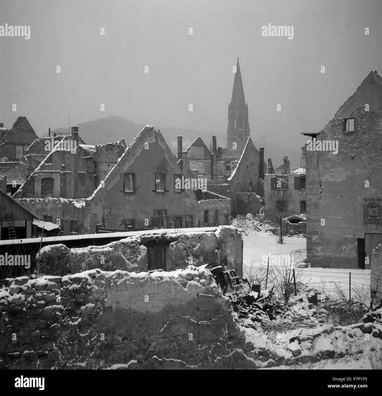 Die Ruinen der zerstörten Häuser im Schnee, im Hintergrund das Freiburger Münster, Ca. 1945, Freiburg, Deutschland Stockfoto