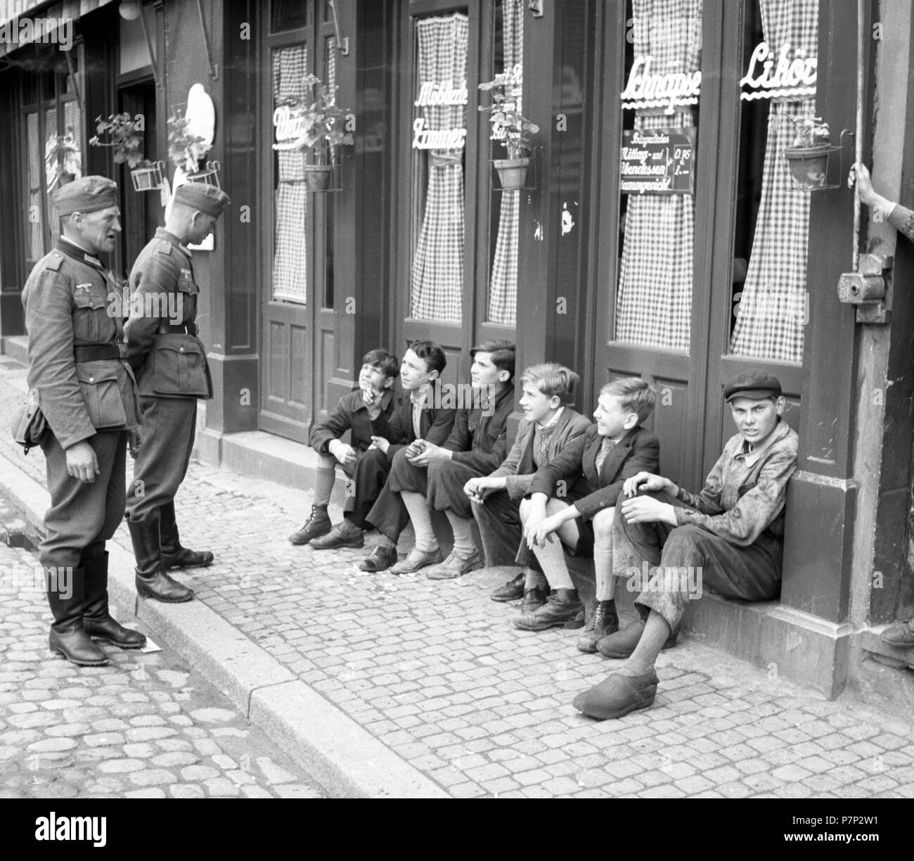 Ca. 1939,1941, Training, zwei Soldaten der Wehrmacht im Gespräch mit Jungen auf dem Bordstein, Ulm, Deutschland Stockfoto