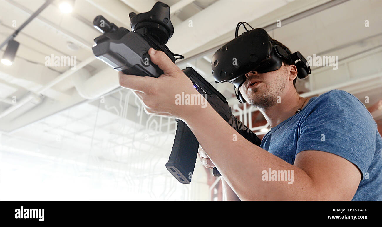 Kerl spielen VR sniper spiel mit Gewehr und Gläser Stockfoto