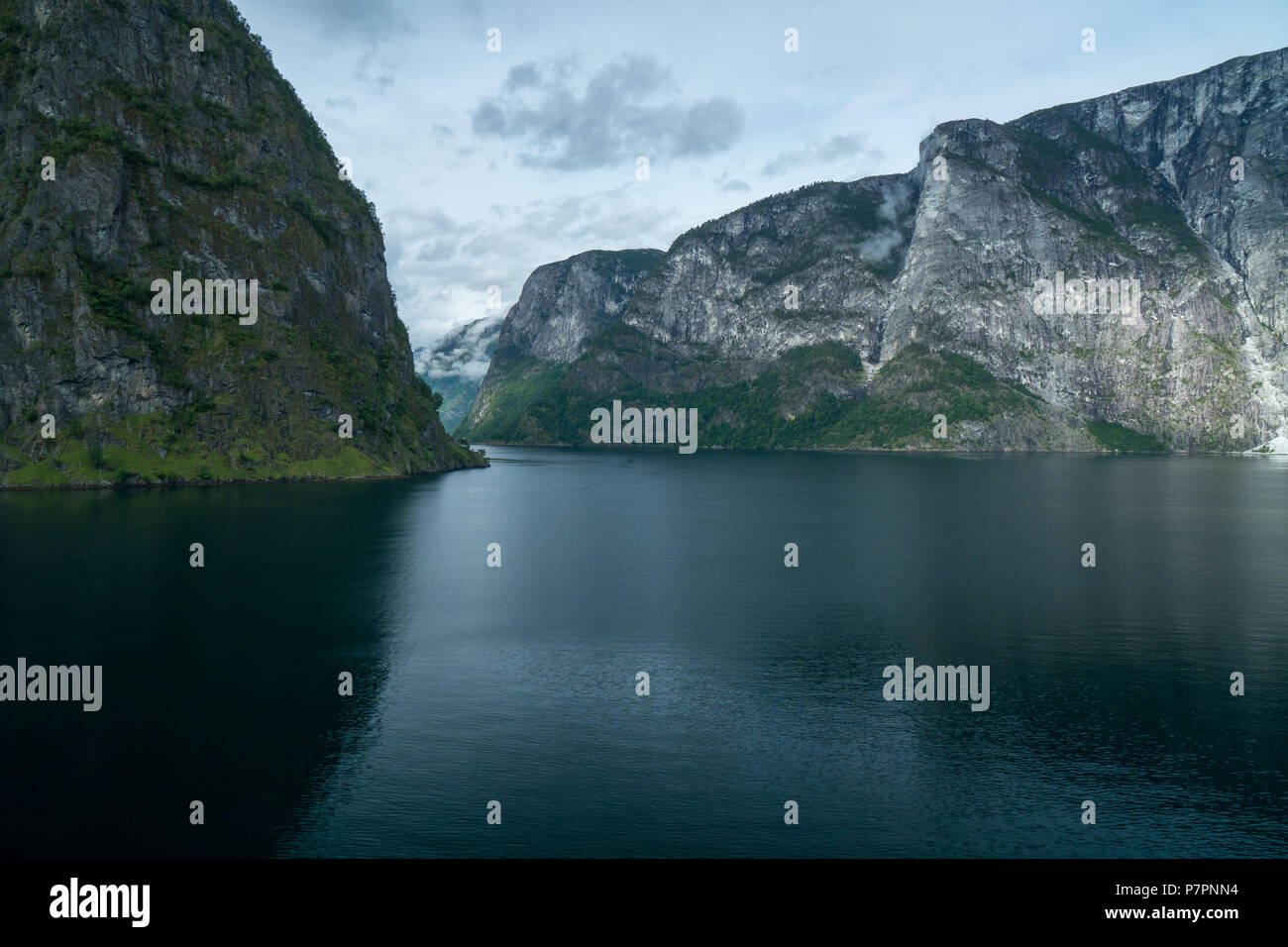 Massive Geiranger Fjord in Norwegen von einem Kreuzfahrtschiff gesehen mit Licht durch die Wolken Stockfoto