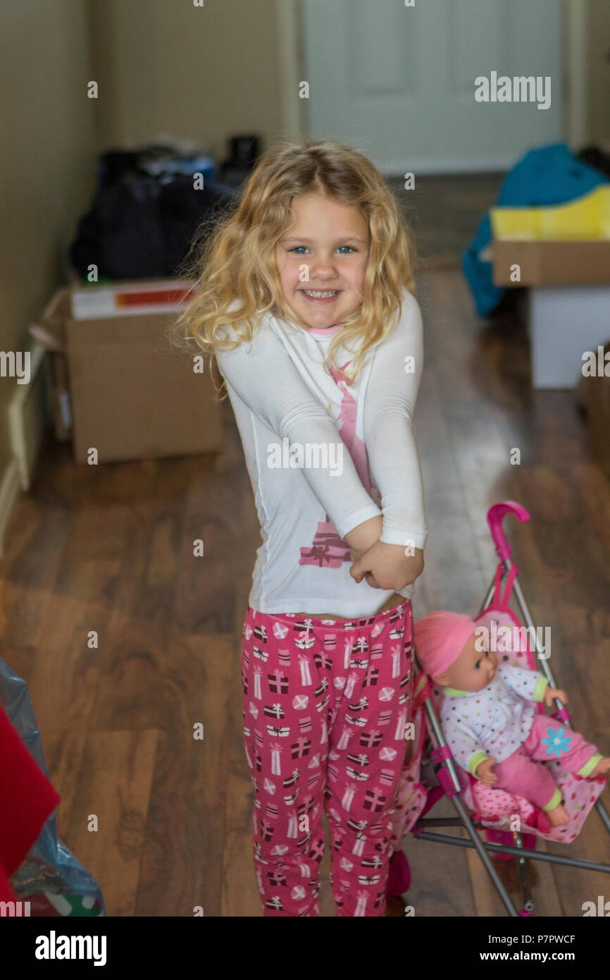 Hübsches, 3 Jahr alt, blondes Mädchen glücklich und lächelnd mit neuen Weihnachtsgeschenk. Cranbrook, BC, Kanada. Model Release #114 Stockfoto