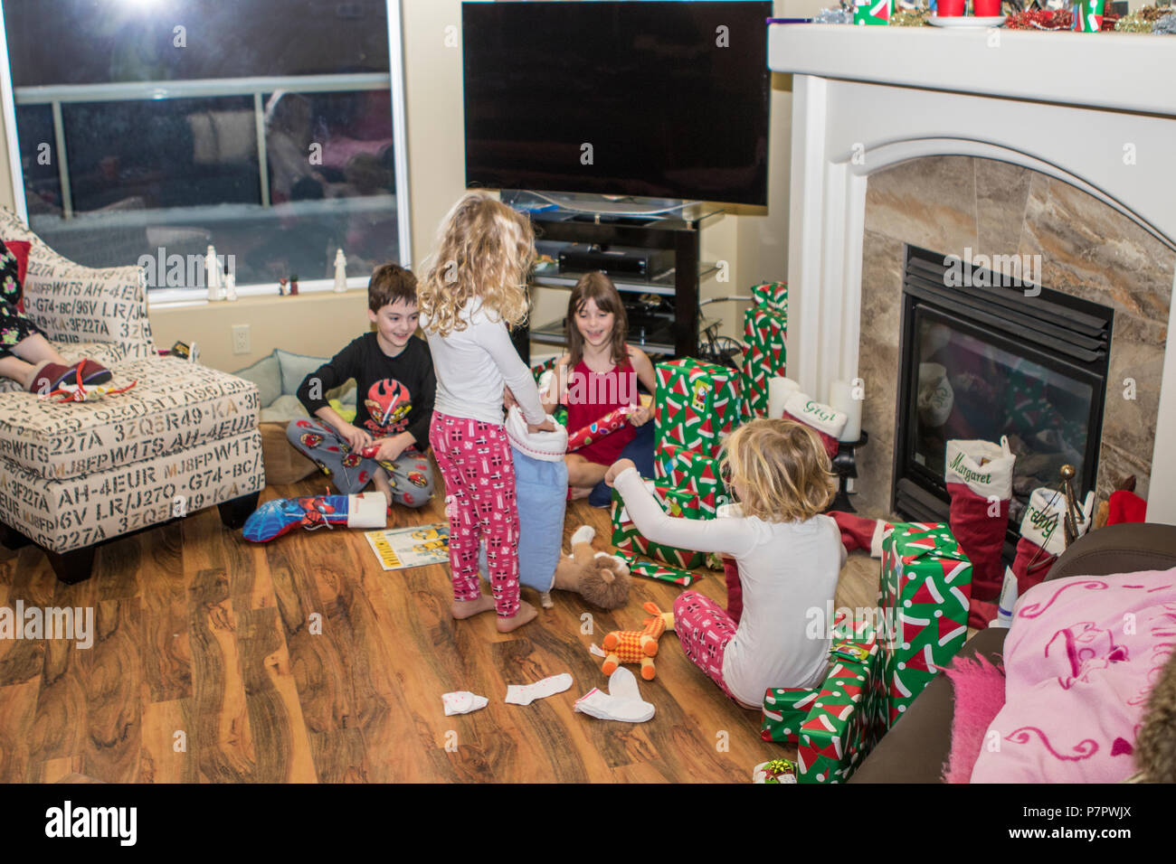 Vetter, vor dem Kamin, Spielen mit Weihnachtsgeschenken, im Alter von 3 bis 9. in Cranbrook, BC, Kanada. Model Released von Links nach Rechts - #105, #104, #114, #11. Stockfoto