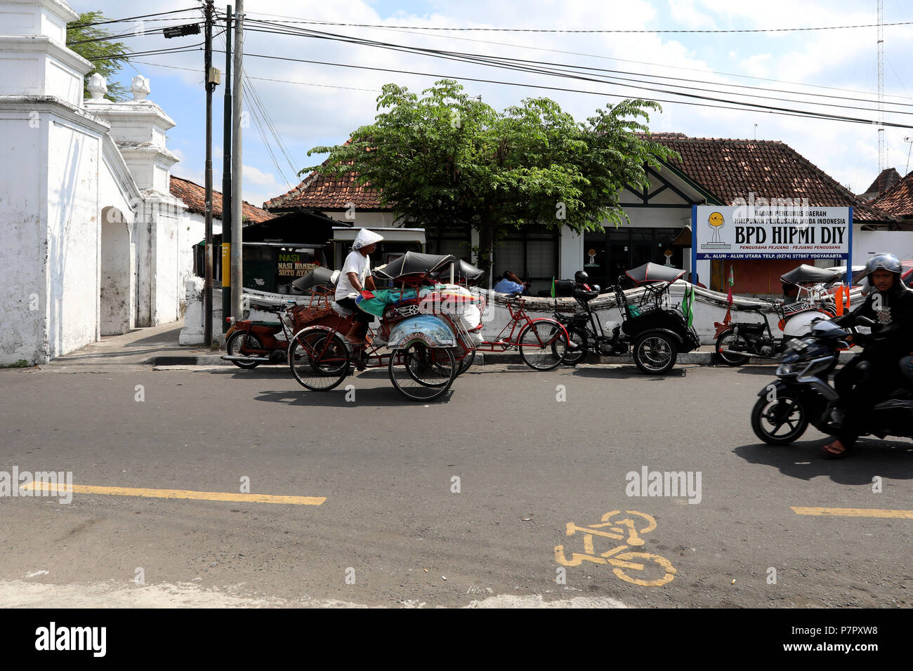 Jogjakarta, Indonesien - 22. Juni 2018: eine Rikscha Fahrer Zyklen seine Karre entlang einer Straße in das Sultan's Palace Complex in Jogjakarta Stockfoto