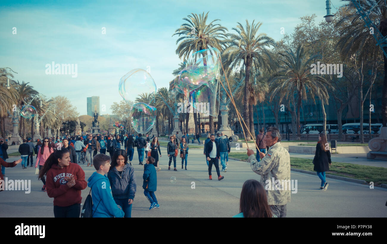 BARCELONA, SPANIEN - 27. März 2017: Fußgänger-Allee in Ciutadella Park durch eine Straße Mann, unterhält Kinder die immensen/giant Soap bu Animierte Stockfoto