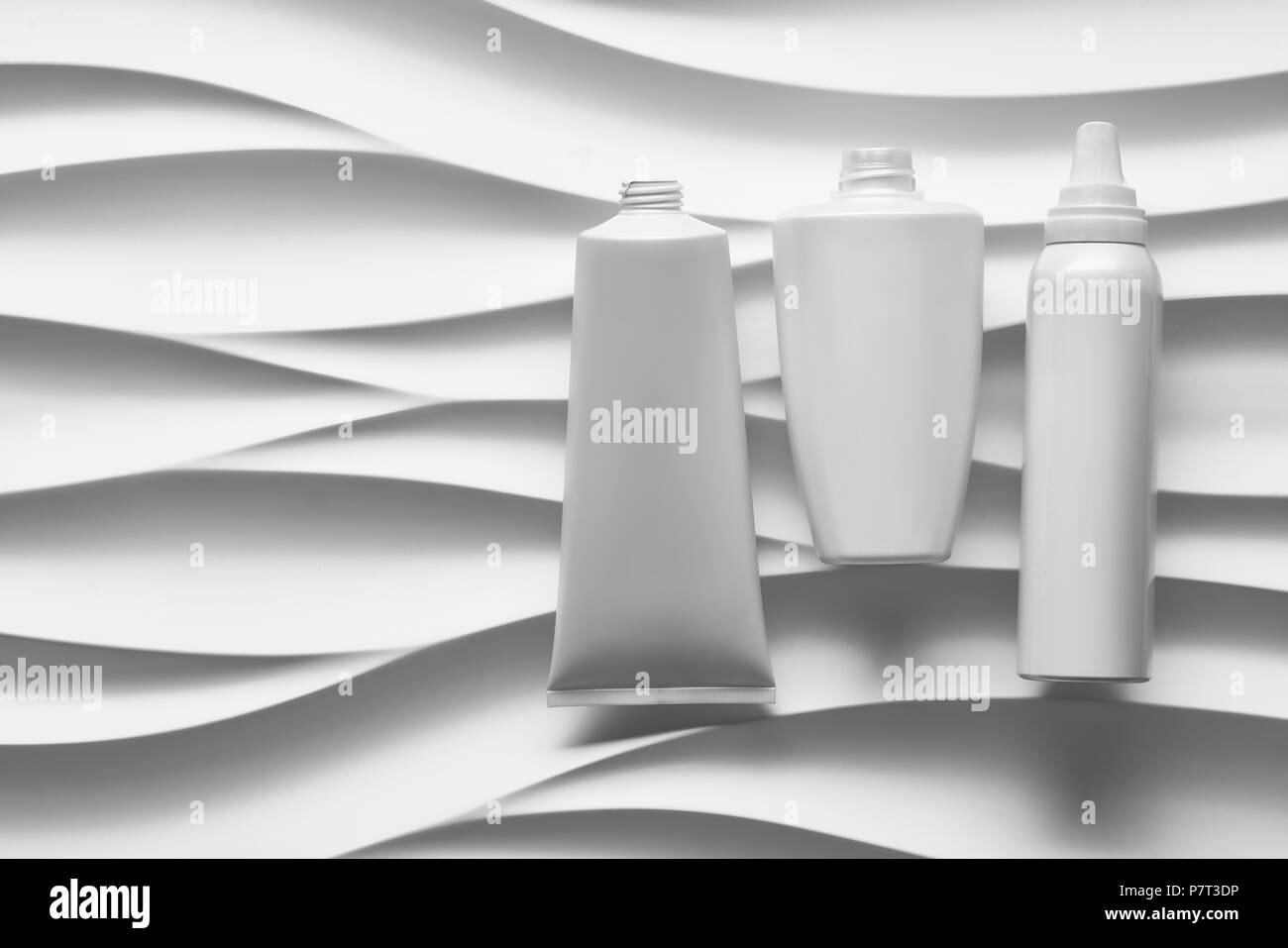 Schönen format Poster mit glatten grauen Wellen abstrakt Hintergrund mit grau-Tonarten, mit sauberen weißen Kunststoffbehälter: Flaschen, Creme jar Stockfoto
