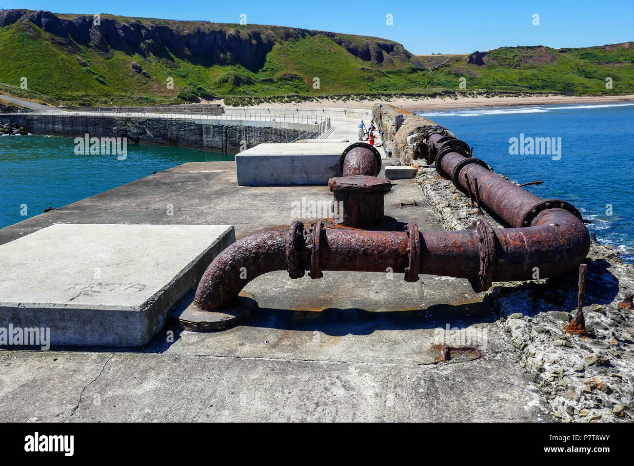 Alte rostige Rohre und heißer blauer Sommer Tag als Küstenstadt Skinningrove, North Yorkshire Stockfoto