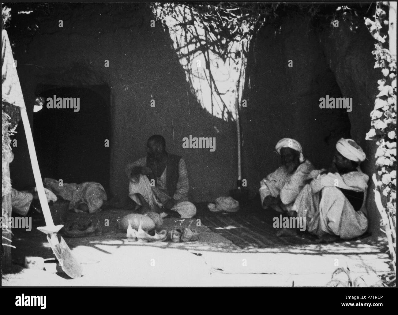 Afghanistan, Andkhoi (Andkhoy, andkhvoy) Lehrwerk:; Sitzende Männer vor einem Haus. Von 1939 bis 1940 64 CH-NB-Afghanistan, Andkhoi (Andkhoy, andkhvoy) - Menschen - Annemarie Schwarzenbach - SLA-Schwarzenbach-A -5-20-095 Stockfoto