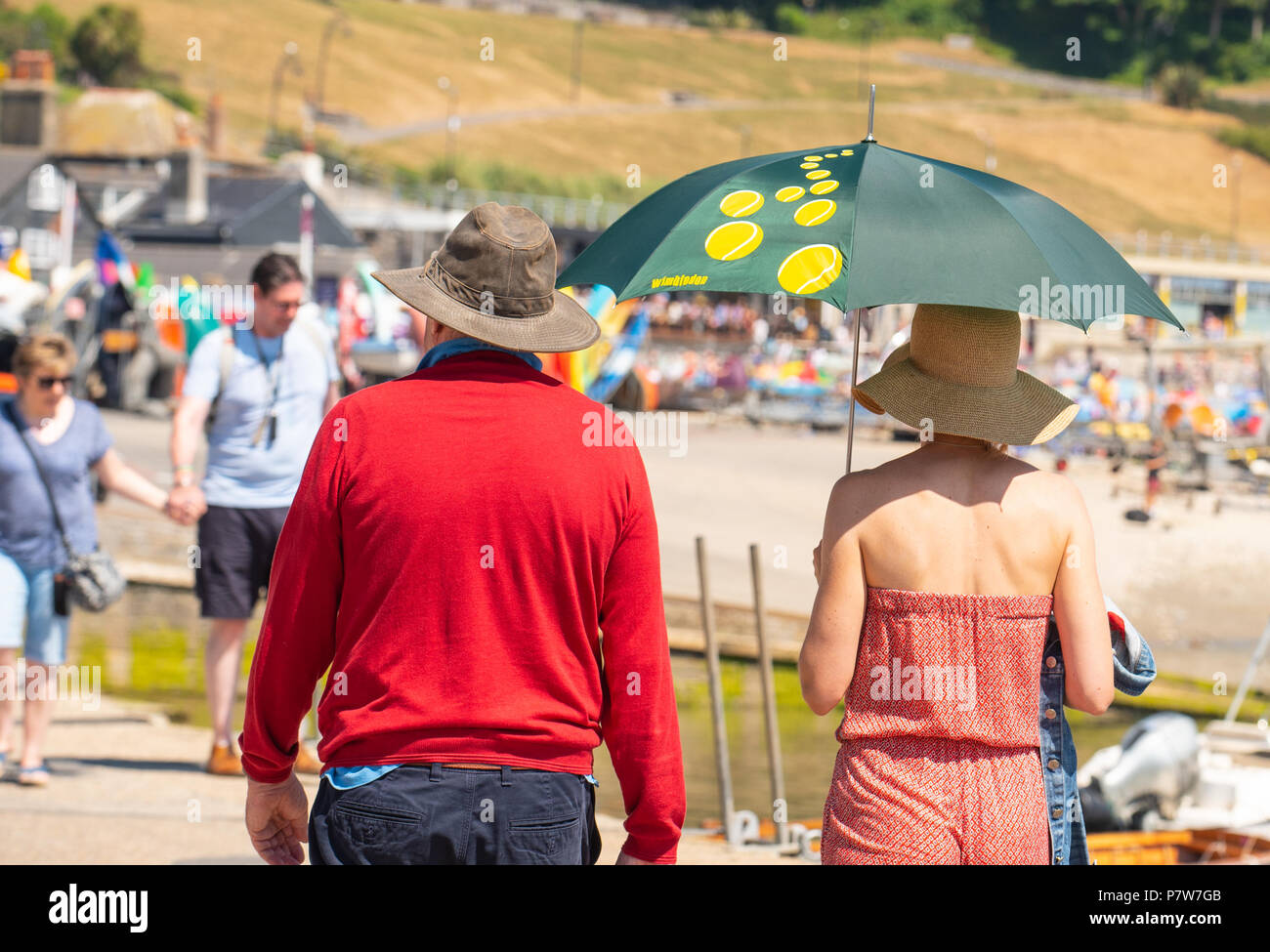 Lyme Regis, Dorset, Großbritannien. 8. Juli 2018. UK Wetter: Weitere glühend heiß und sonnig Sonntag in Lyme Regis. Die Jurassic Coast braten wieder als Besucher und Einheimische in Scharen zu den Strand auf Weiteres sizzling Sonntag an der Südküste. Ein Paar genießt die Sonne am Strand. Credit: Celia McMahon/Alamy leben Nachrichten Stockfoto