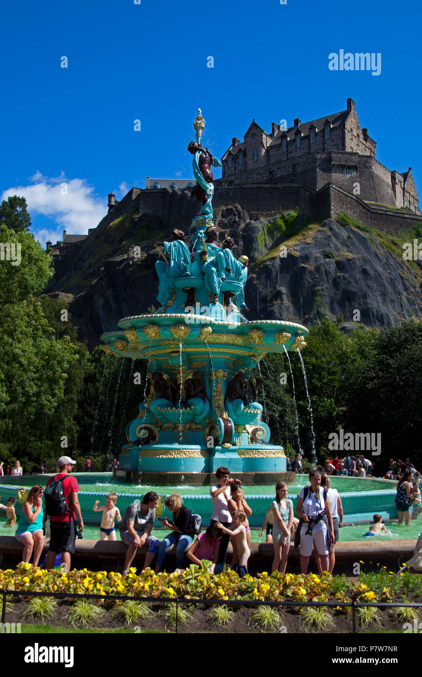 Edinburgh, Schottland, Großbritannien. Vom 8. Juli 2018. Ross Brunnen, West Princes Street Schalter Gärten am Tag, Massen von Familien und Touristen in der Sonne zu sehen, die zirkusvorstellungen und Edinburgh's School Pipe Band und Baden im Brunnen Wasser, das im Jahr 2010 geschaltet wurde. Stockfoto