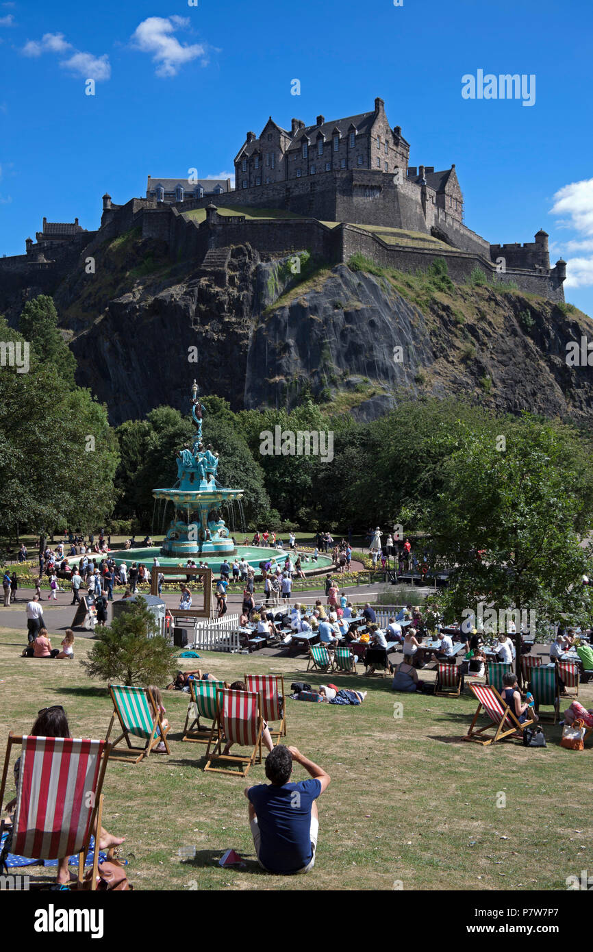 Edinburgh, Schottland, Großbritannien. Vom 8. Juli 2018. Ross Brunnen, West Princes Street Schalter Gärten am Tag, Massen von Familien und Touristen in der Sonne zu sehen, die zirkusvorstellungen und Edinburgh's School Pipe Band und Baden im Brunnen Wasser, das im Jahr 2010 geschaltet wurde. Stockfoto