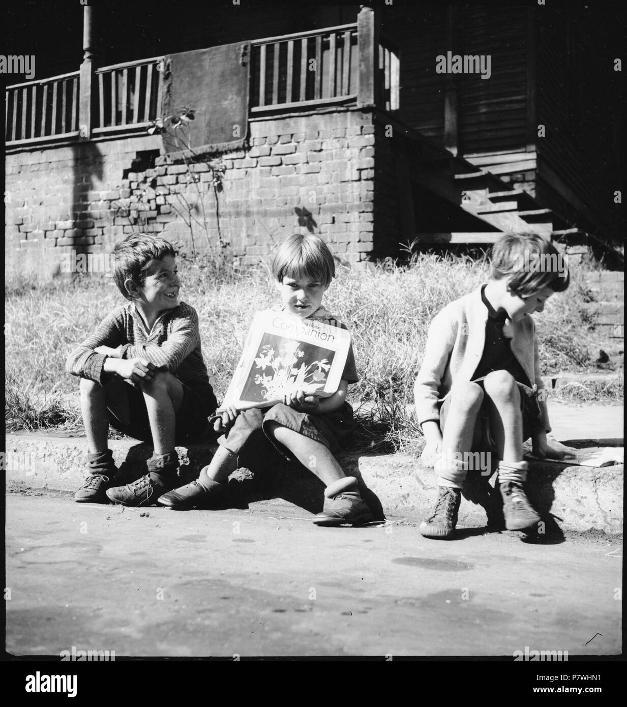 USA, Knoxville/TN Lehrwerk:; Drei Kinder am Strassenrand sitzend, eines oft hält eine Zeitschrift. Von 1936 bis 1938 85 CH-NB-USA, Knoxville - TN - Menschen - Annemarie Schwarzenbach - SLA-Schwarzenbach-A SSL-100-245 Stockfoto