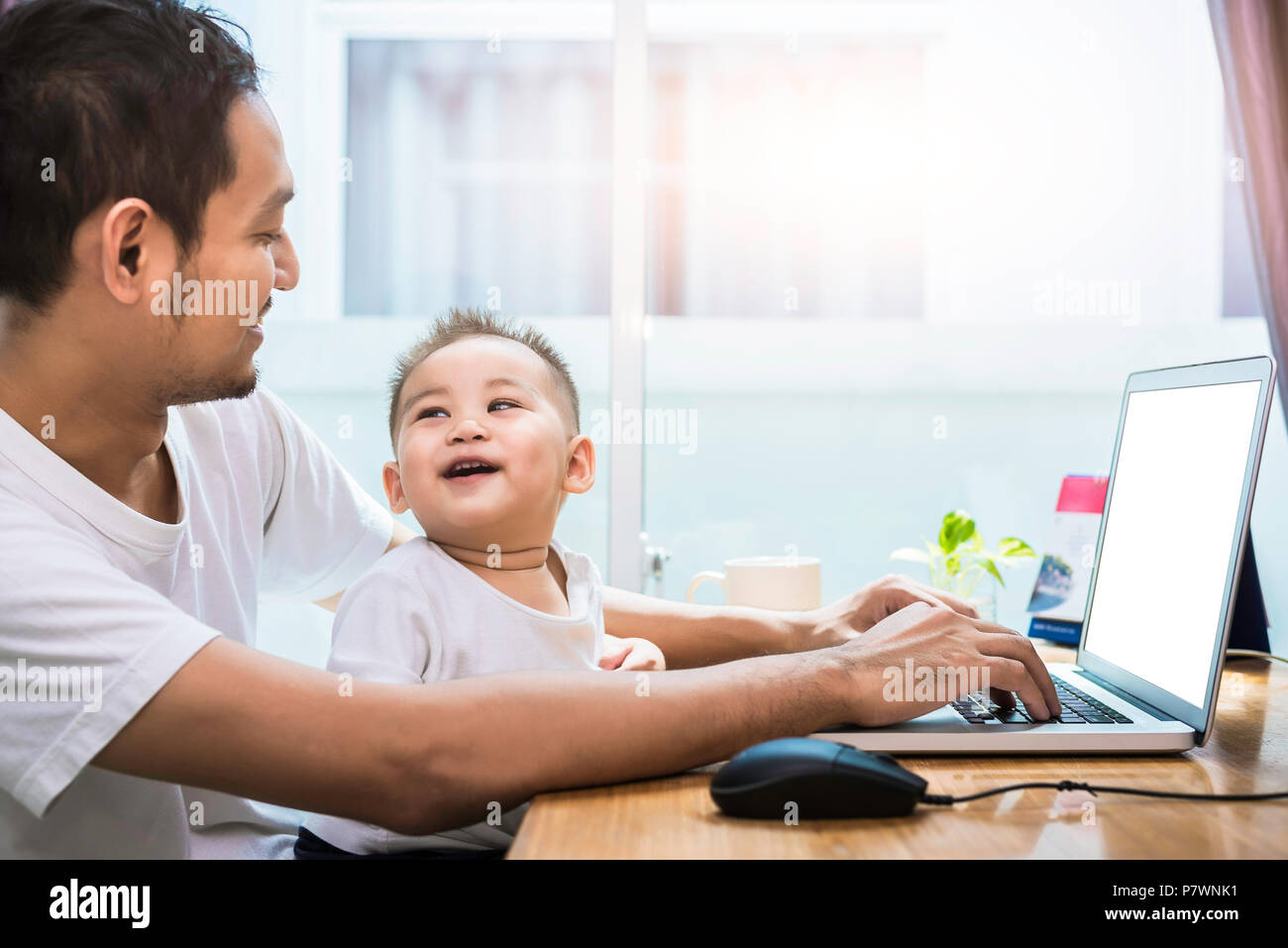 Single Papa und Sohn mit Laptop glücklich zusammen. Technologie und Lifestyle Konzept. Glückliche Familie und Baby Thema. Stockfoto