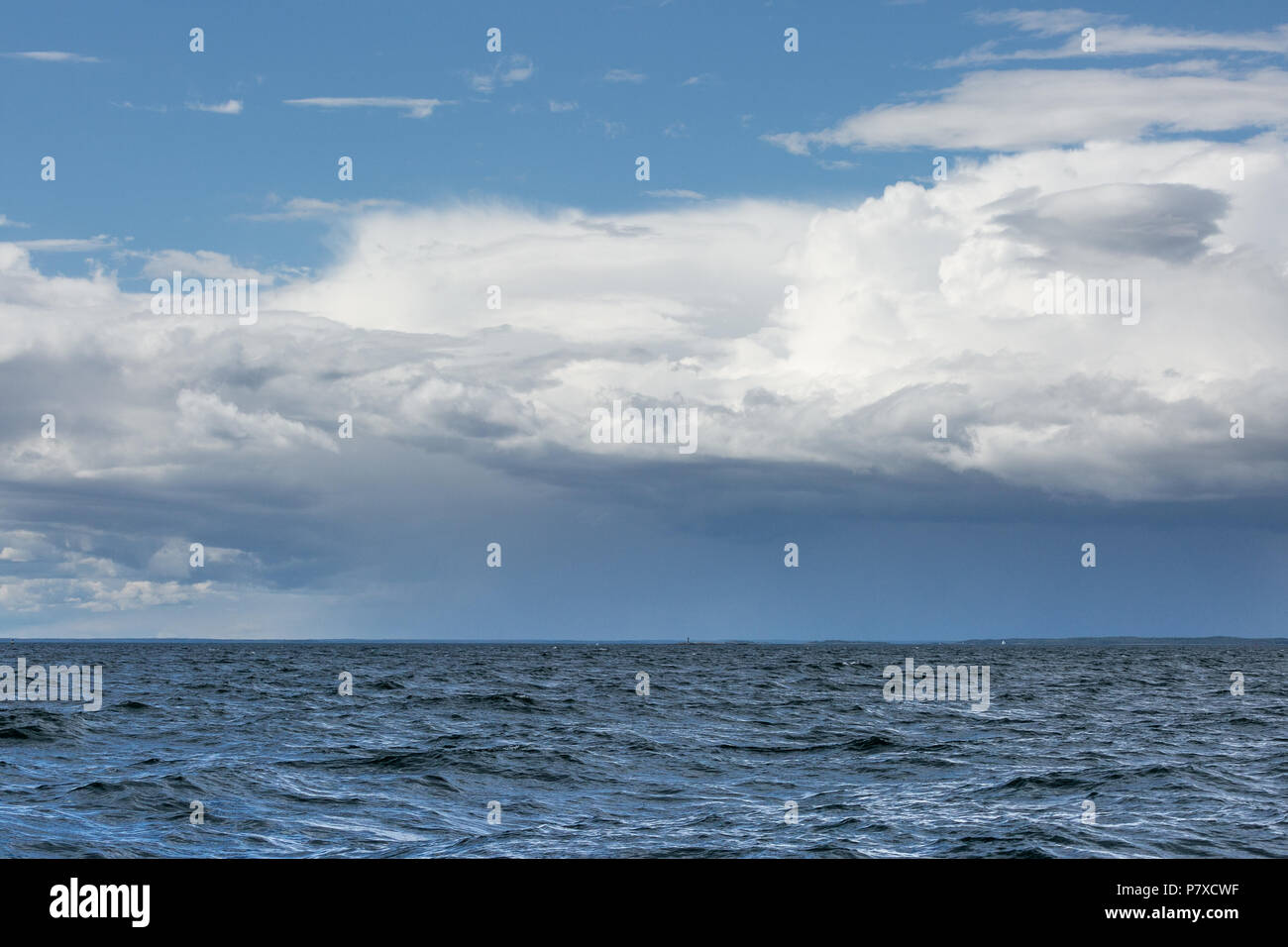 Ein Leuchtturm im Meer, mit dramatischen Himmel. Stockfoto