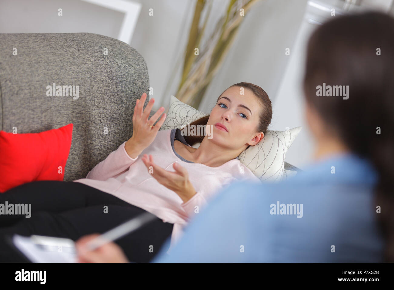 Junge Frau auf der Couch liegend im Doktorbüro Stockfoto
