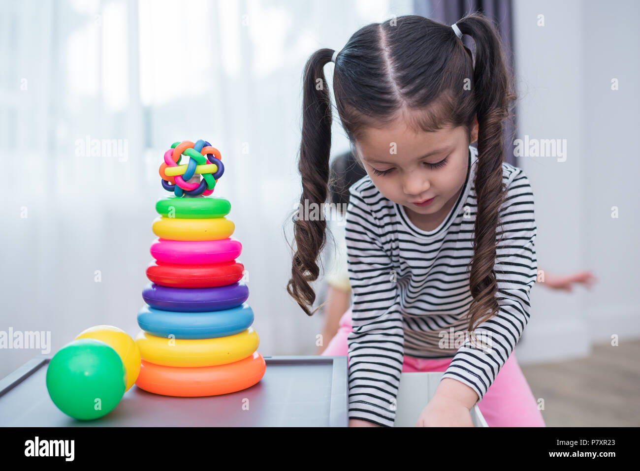 Kleine Mädchen spielen kleines Spielzeug Bänder in Home Kleine Mädchen spielen kleines Spielzeug Bänder in Home