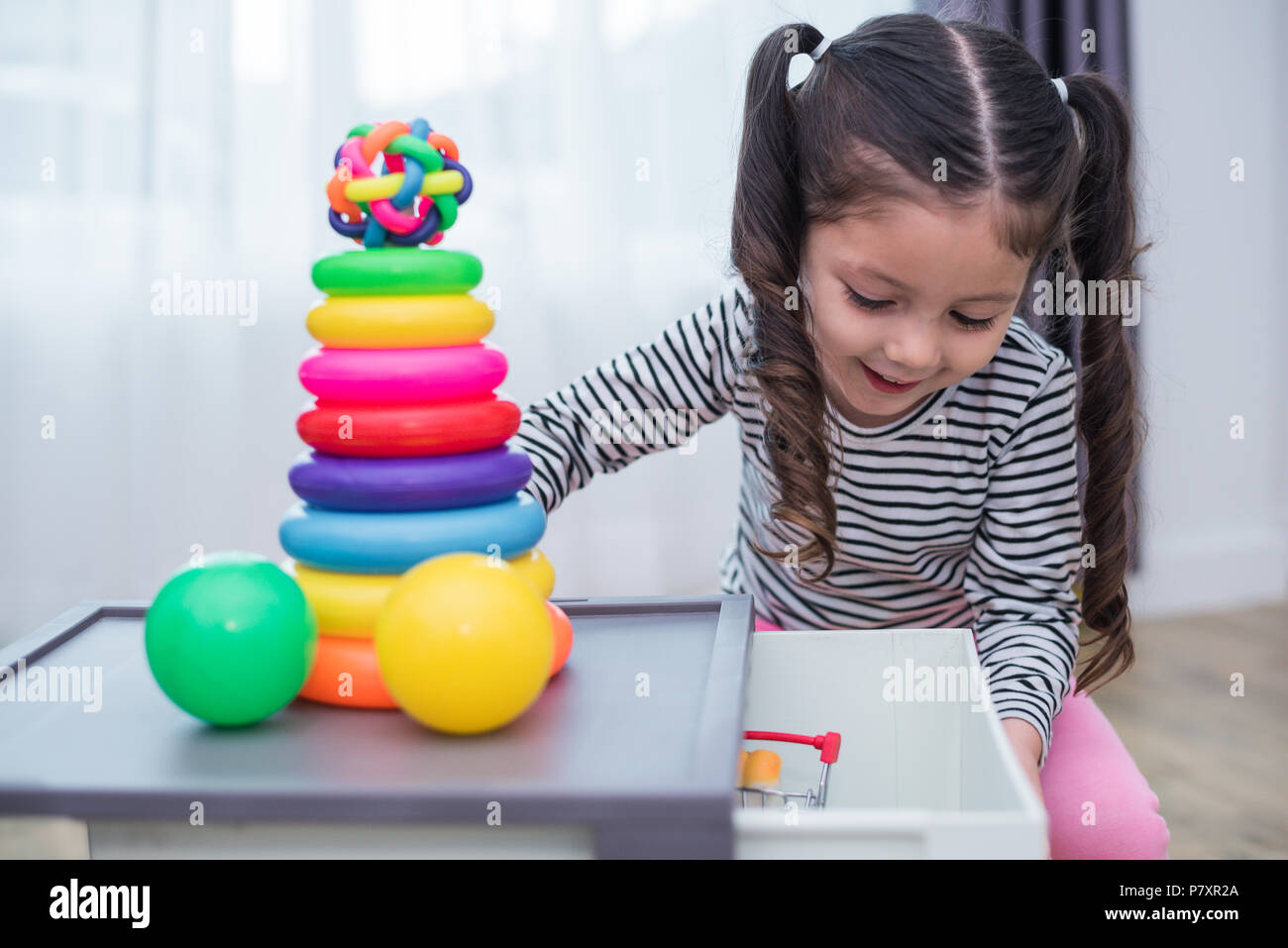 Kleine Mädchen spielen kleines Spielzeug Bänder in Home Kleine Mädchen spielen kleines Spielzeug Bänder in Home