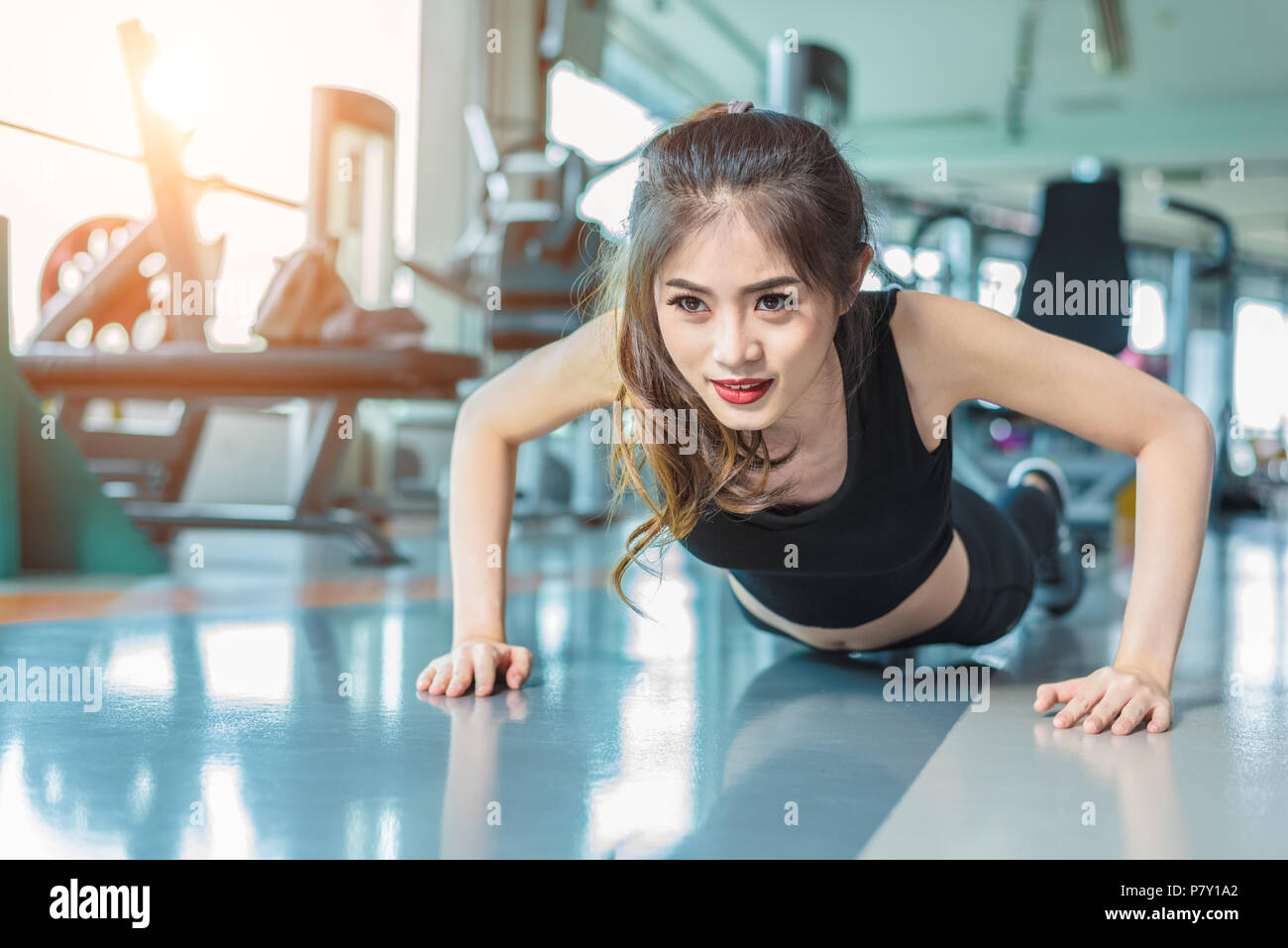 Asiatische Frau fitness Mädchen tun drücken ups bei Fitness Gym. Healthcare und Gesundes Konzept. Ausbildung und Körper aufbauen Thema. Stärke und Schönheit Konzept Stockfoto